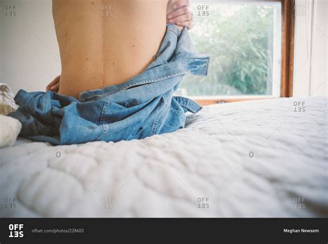 woman    shirt  siting   edge   bed stock