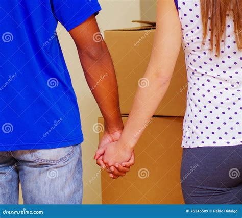 Interracial Couple Holding Hands Seen From Behind With Stacked Boxes