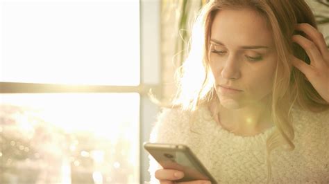 unhappy woman texting message on mobile close up of sad woman looking