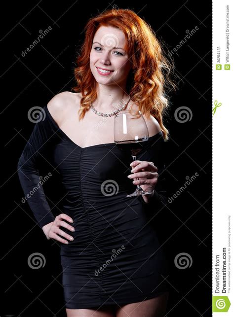 woman with beautiful red hair is drinking a glass of red
