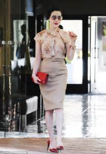 dita von teese looks feminine in floral blouse but turns up the heat with sexy red bag and