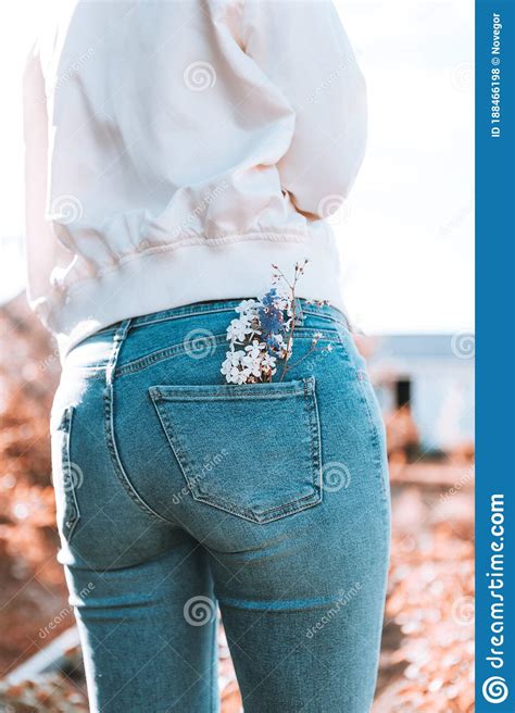 the girl is standing with her back in blue jeans flowers