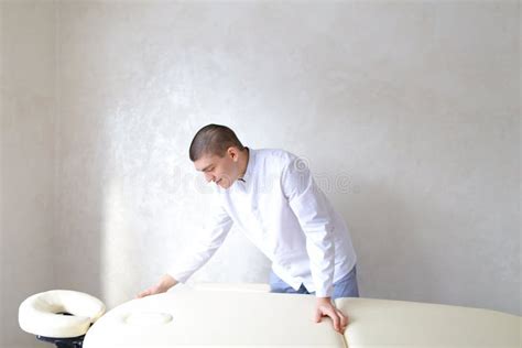 professional male massage therapist preparing to receive patient stock