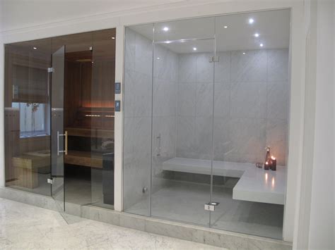 this stylish steam room has white corian benches and large format tiles to the walls the