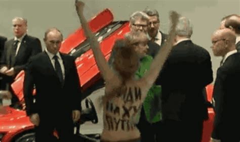 vladimir putin greeted by topless protester gives her two thumbs up
