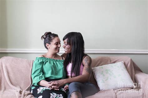affectionate lesbian couple on sofa photograph by caia image science
