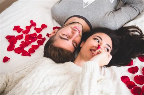 couple lying on bed head with head surrounded by rose