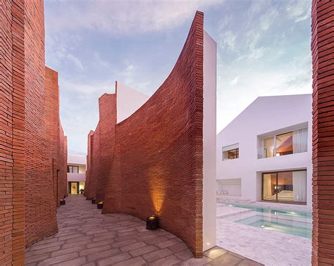 boutique hotel fuses multi curved brick walls  pure white geometries