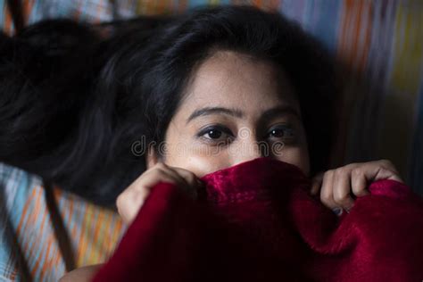 Young Indian Brunette Woman In Sleeping Wear Lying On A Bed Stock Image
