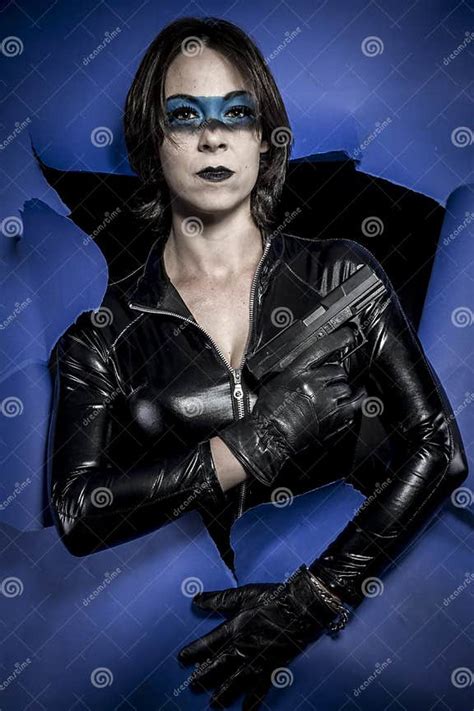Portrait Brunette In Black Latex Costume With Pistol Over Broken Stock