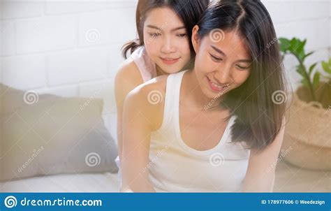 asian lesbian couple hug each other on bed in morning at