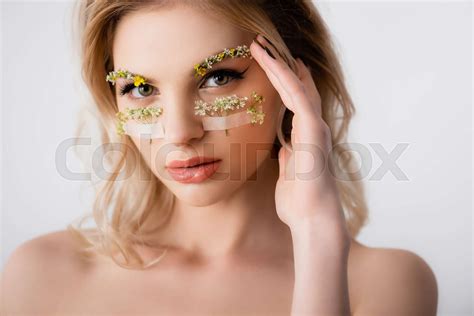 Naked Beautiful Blonde Woman With Wildflowers Under Eyes And Hand Near