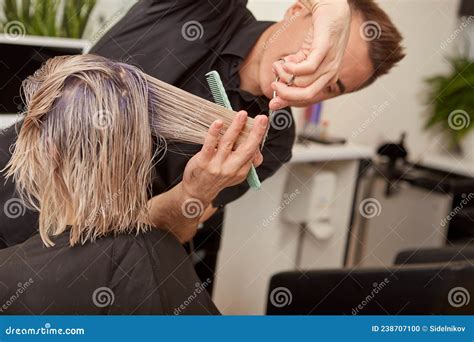 Skillful Hairdresser Cutting Woman Blonde Hair In Beauty Salon Stock