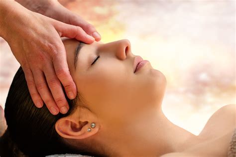 Massage Therapist Touching Sensitive Area Between Eyes On Woman Stock