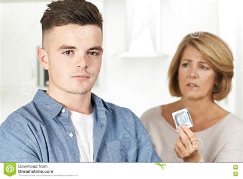 mother talking to teenage son about contraception stock