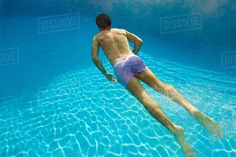 young man swimming underwater  swimming pool stock photo dissolve