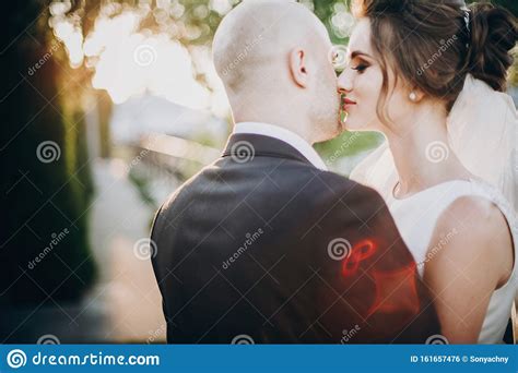 Gorgeous Bride And Groom Gently Kissing In Sunset Light