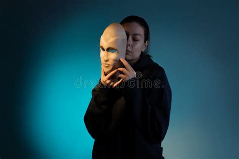 hiding   mask  young woman   dark hoodie hides  face   mask stock photo
