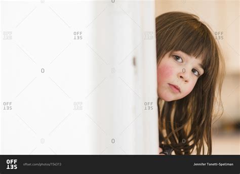 portrait   girl peeking   door stock photo offset
