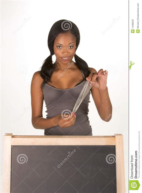 african american woman with condom by blackboard stock