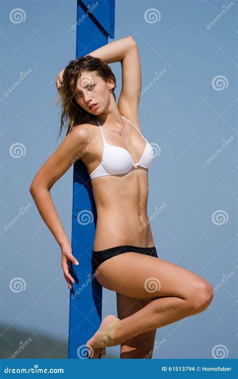 vrouwelijk geschiktheidsmodel die tegen een blauwe pijler leunen stock foto image  benen