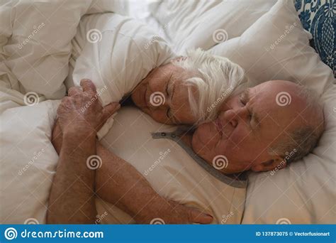 senior couple sleeping together in bedroom stock image