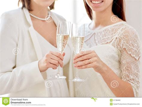 close up of lesbian couple with champagne glasses stock