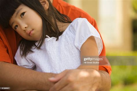 asian girl sitting on fathers lap foto de stock getty images