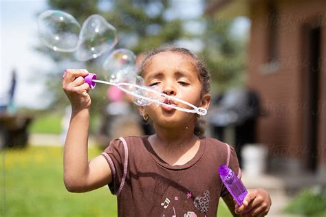 cute young child blowing bubbles  stocksy contributor anya