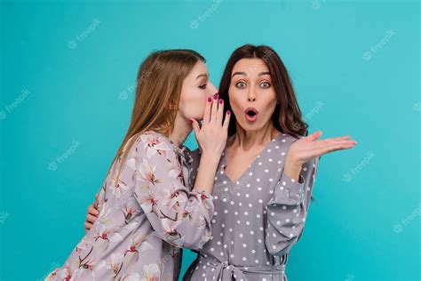 Premium Photo Young Woman Whispers A Secret To Her Girl Friend