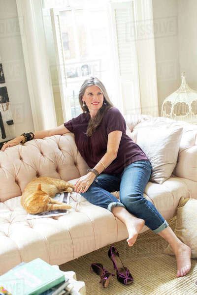 stylish mature woman sitting  sofa  ginger cat stock photo dissolve