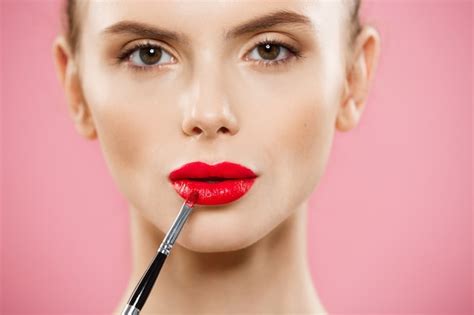 Free Photo Beauty Concept Woman Applying Red Lipstick With Pink
