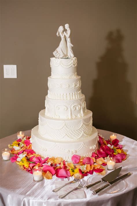 ornamental white tiered wedding cake with bride and groom