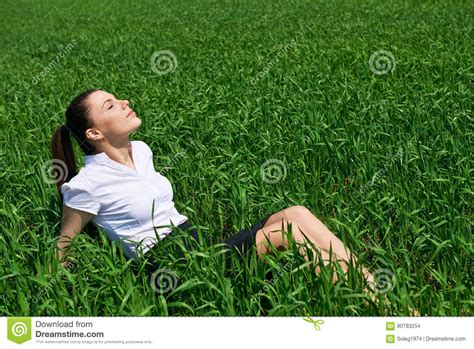 business woman relaxing in green grass field outdoor under sun