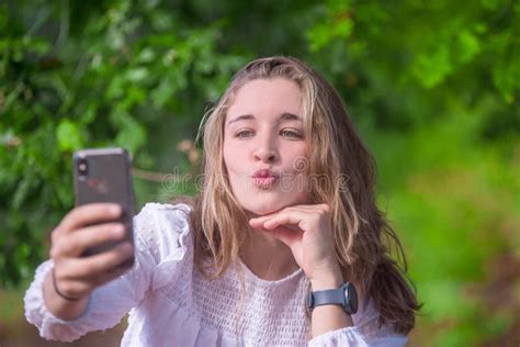 Pretty Young Woman Making A Selfie In Nature With Her Smartphone Stock