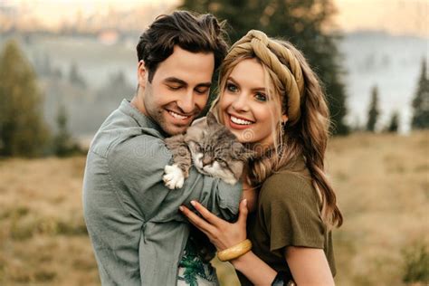 beautiful sensual couple hug together with the cat and smile cheerfully