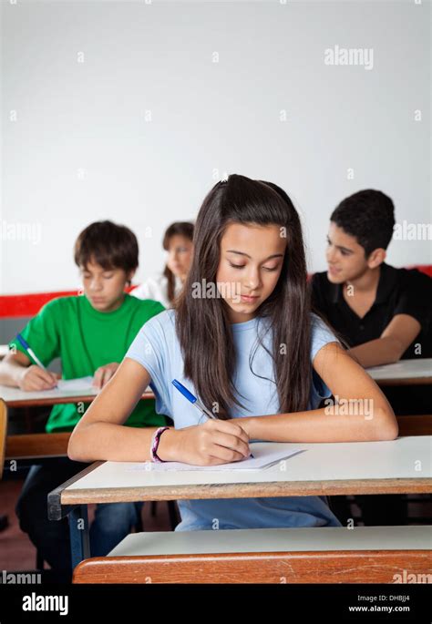 female student writing paper  desk  examination stock photo alamy