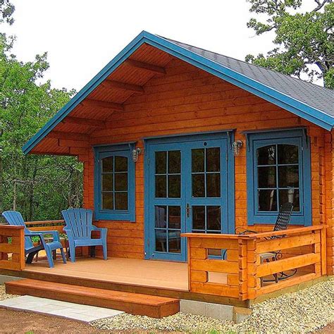 A Small Wooden Cabin With Blue Doors And Two Chairs On The Front Porch