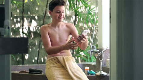 man in bath towel texting on smartphone in the bathroom