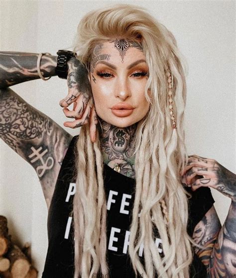 A Woman With Long Blonde Hair And Tattoos