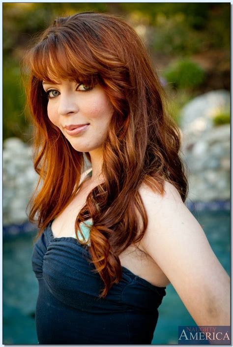 A Woman With Long Red Hair Posing For A Photo