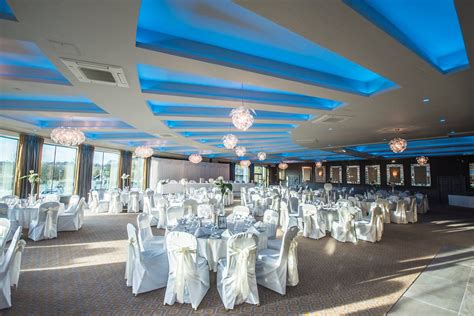 banquet room  set   white linens  blue ceiling lights