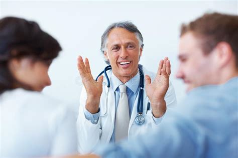 Doctor Explaining To His Patients Portrait Of Happy Mature Doctor