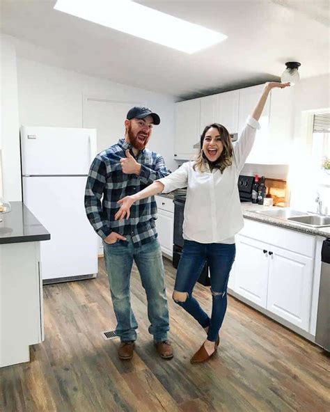 man  woman standing   kitchen   arms    ceiling smiling