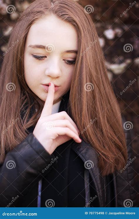 nastoletnia dziewczyna z jej palcem jej wargi dla ciszy zdjęcie stock