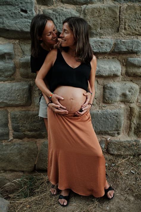 Vertical Closeup Of A Pregnant Lesbian Couple Doing A Photoshoot In A