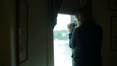 an undercover detective photographing a woman leaving her home then reporting status via a small