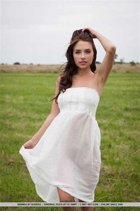 beautiful brunette girl niemira removes white dress to pose nude in hay field