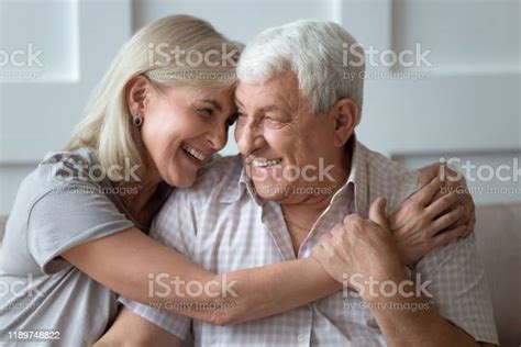 laughing mature hoary pleasant woman embracing happy 80s husband stock