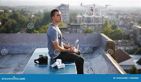 young technician flying uav drone  remote control  rooftop stock photo image  flying